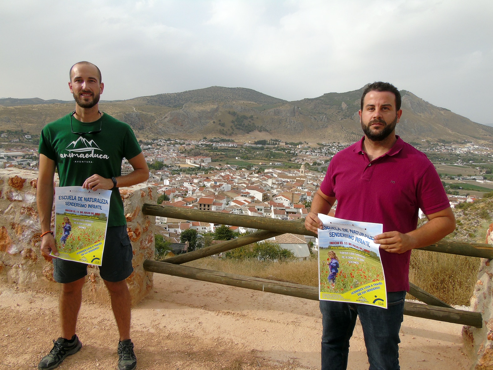 Samuel Écija Y Antonio Campaña Muestran El Cartel De La Actividad En El Parque Periurbano.