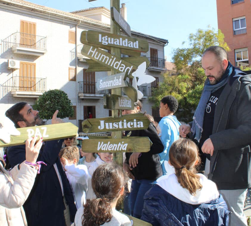 El Concejal De Igualdad Y El Alcalde Ayudan A Los Niños A Colgar Los Letreros. Foto: Calma